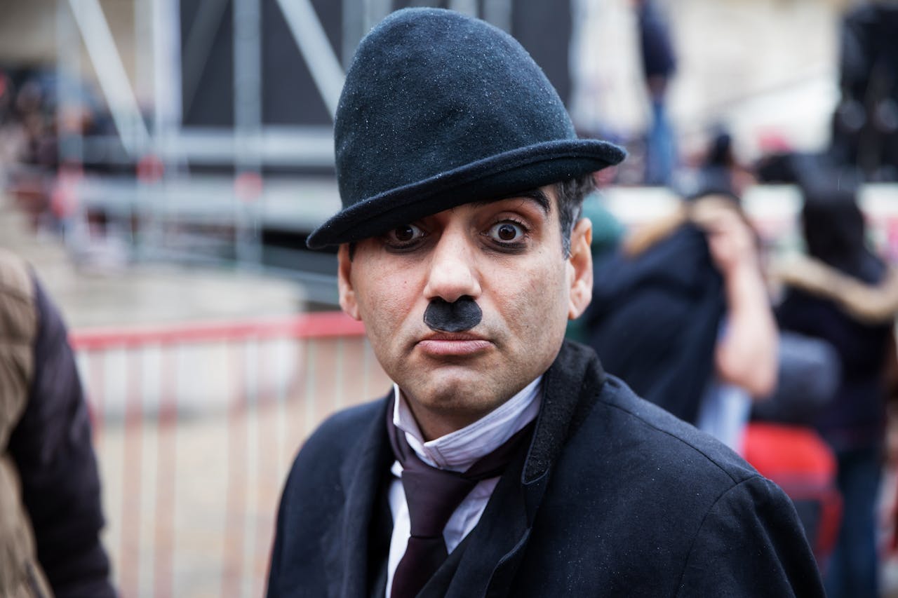 Man with a Mustache, and Wearing a Black Hat, Making a Facial Expression on a Street